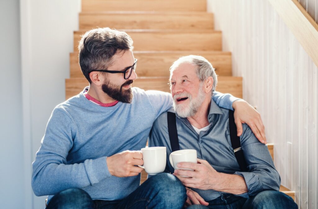 An adult child spends quality time with their mature parent over a cup of coffee.