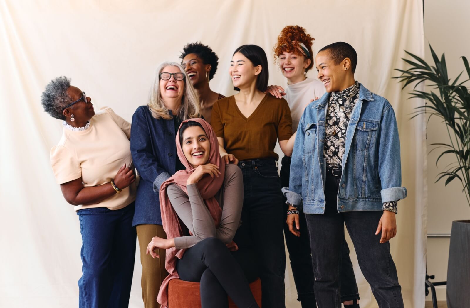 A group of intergenerational friends gather for a photoshoot, laughing, smiling, and having a good time together